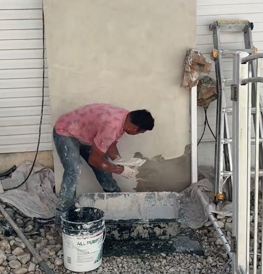 Air Duct Dynasty technician applying parging repair to an exterior chimney structure