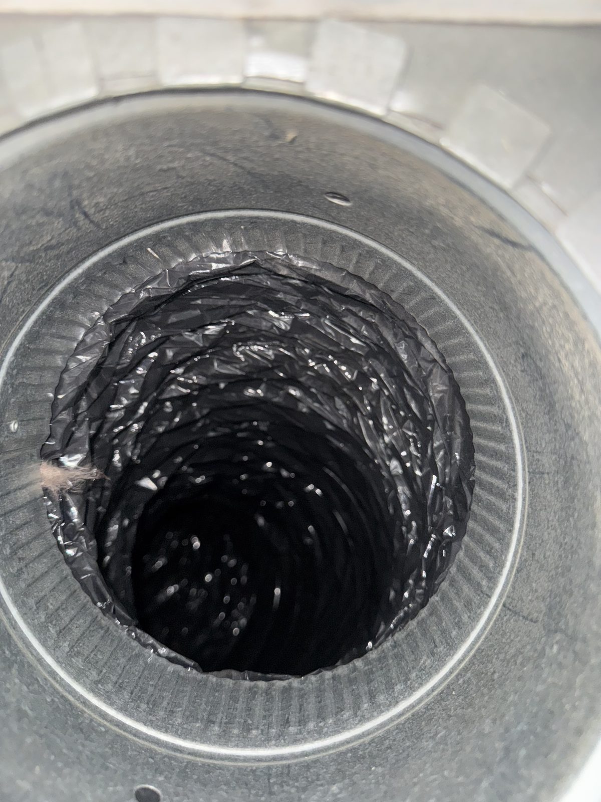 The same flexible air duct after professional cleaning, with bare metal walls and no dust buildup