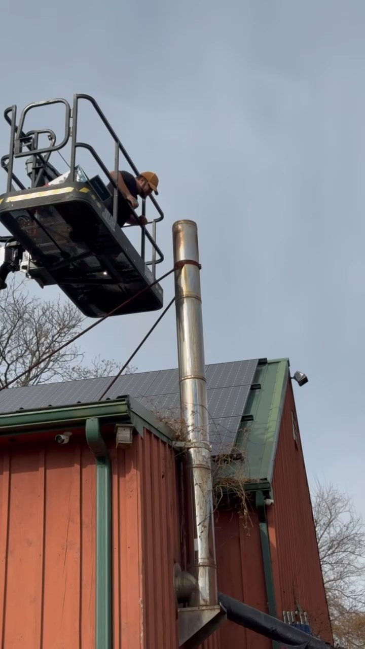 Boom lift basket alongside a chimney with a metal liner