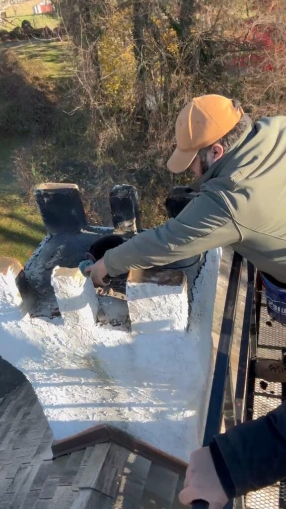 Air Duct Dynasty technician working on a chimney from an elevated boom lift